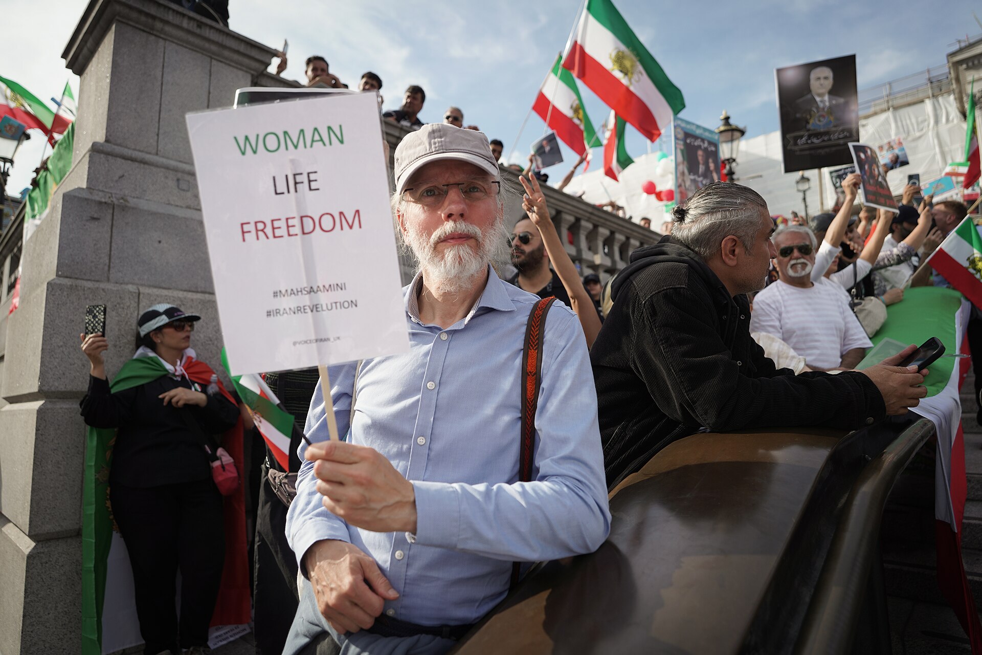 En stor solidaritetsskare med kvinde, liv, frihed, der marcherer med iranske flag og plakater