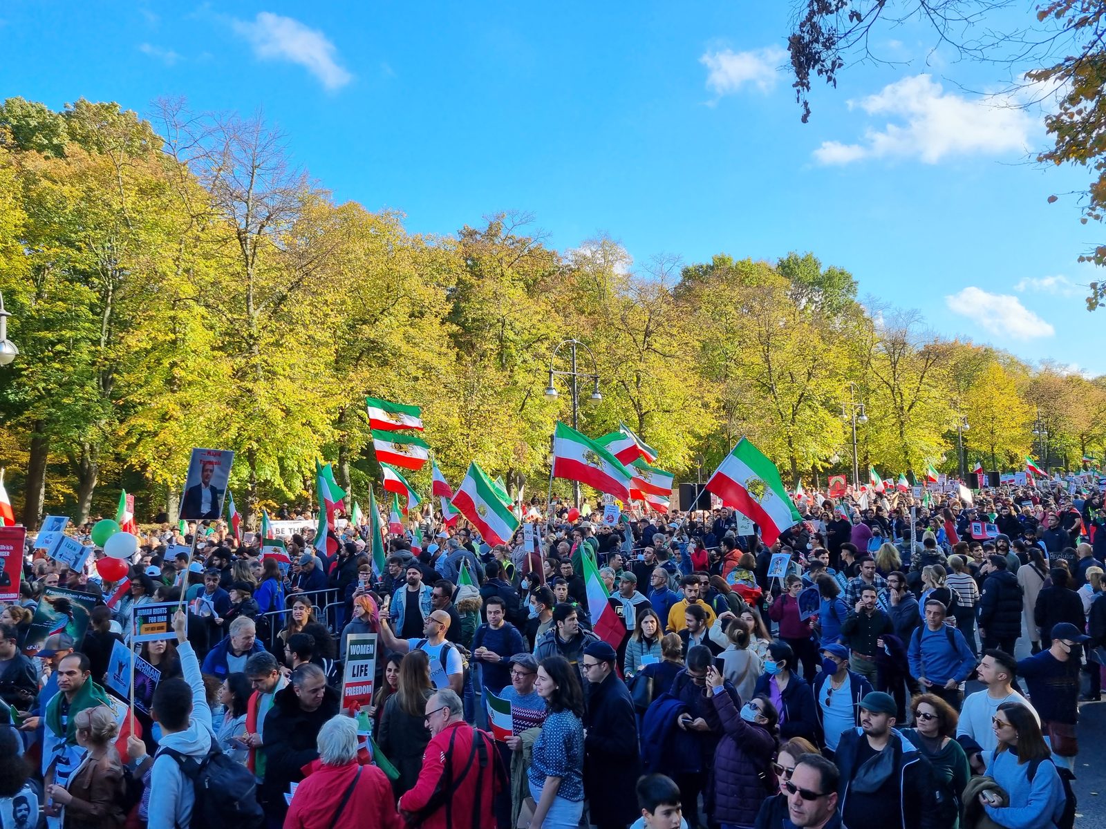 جمعیت در برلین با در دست داشتن عکس‌های مهسا امینی در جریان تجمع همبستگی اکتبر ۲۰۲۲.